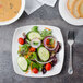 A white rectangular Bon Chef porcelain plate with a salad.