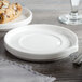 A white Bon Chef porcelain saucer on a table with utensils