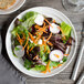 A close up of a salad with radishes, carrots, and lettuce on a white Bon Chef porcelain plate.