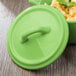 A green porcelain lid with a handle.