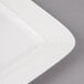 A close-up of a white rectangular porcelain plate with circles on the edge.