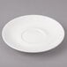 A white porcelain saucer with a circular pattern on the edge.