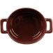 A close-up of a brown porcelain oval cocotte with handles.
