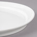 A close-up of a Bon Chef white porcelain plate with a rim.