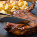 A plate of food with a Walco stainless steel dinner knife cutting meat.