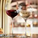 Two Chef & Sommelier wine glasses on a table with a glass of red wine.