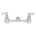 A Fisher brass wall mounted faucet base with swivel stems and lever handles.