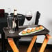 A Cambro Tavern Tan non-skid serving tray on a table with food and wine.