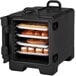 A black front loading Cambro food and tray pan carrier with food on trays inside.