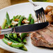 A Walco Pacific Rim small knife on a plate of food with a fork.