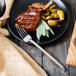 A Walco Erik stainless steel table fork on a plate of food