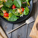 A plate of salad with a Walco Erik stainless steel salad fork.