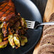 A plate of food with a Walco stainless steel dinner fork on a table.