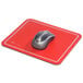 A red Kelly Optical mouse pad with a silver computer mouse on it.