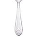 A Walco stainless steel demitasse spoon with a silver design on the handle.