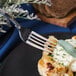 A Walco Luxor stainless steel dinner fork on a plate with food.