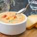 A Walco Erik stainless steel bouillon spoon in a bowl of soup.