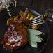 A Walco Luxor stainless steel table fork on a plate of meat and brussels sprouts.