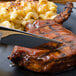 A plate of steak and macaroni with a Walco Erik stainless steel table knife.