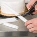 A person cutting a white tube with scissors.