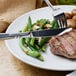 A plate of food with a Walco Meteor stainless steel dinner knife and fork.