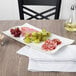 A Villeroy & Boch white porcelain rectangular platter with grapes and meat on it.