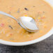 A Walco Lisbon stainless steel bouillon spoon in a bowl of soup.