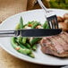 A plate of food with a Walco Saville dinner knife and fork.