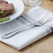 A Walco Meteor stainless steel dinner fork on a white plate with a piece of meat.