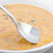 A Walco stainless steel bouillon spoon in a bowl of soup.
