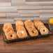 A tray of bagels in American Metalcraft PET basket liners on a wooden table.