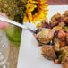 A Walco stainless steel serving spoon in a plate of brussels sprouts.