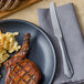 A plate of food with a Walco Danish Pride dinner knife and a napkin.