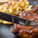 A plate of food with a Walco Danish Pride dinner knife cutting meat.