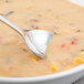 A Walco Meteor stainless steel bouillon spoon in a bowl of soup.