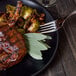 A plate of food with a Walco Lisbon table fork on a table.