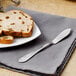 A plate of bread with a Walco Meteor butter knife on a napkin.