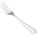 A close-up of a Walco stainless steel utility/salad fork with a white handle.