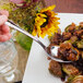 A person holding a Walco Danish Pride stainless steel serving spoon over a plate of food.