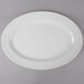 A white Thunder Group oval melamine platter with a white rim on a gray surface.