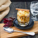 A glass of dessert with a Walco stainless steel dessert spoon and cinnamon sticks.