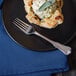 A plate with a pastry and a Walco Barony stainless steel dinner fork on it.