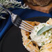 A fork is on a plate with food on it.