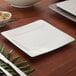 A white Villeroy & Boch Modern Grace square bread and butter plate on a white surface with a black border.