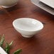 A Villeroy & Boch white bone porcelain dip bowl on a wood table.