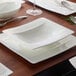 A Villeroy & Boch white bone porcelain deep plate with a spoon on it on a table.