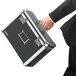 A man in a suit holding a Vaultz black locking file chest.