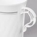 A white plastic coffee mug with a white handle and silver accents.