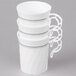 A stack of white WNA Comet coffee cups with silver accents on top.