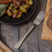 A Walco Marcie stainless steel table fork on a plate of food.